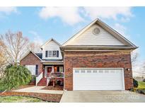 Brick home with a white garage door and landscaping at 129 Bald Cypress Ln, Mooresville, NC 28115