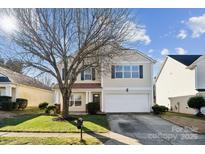 Two-story house with beige siding, attached garage, and a well-maintained lawn at 1411 Ladora Dr, Charlotte, NC 28262