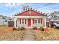 Charming single-story home with a red and beige exterior, and well-manicured landscaping at 208 Lakewood Ave, Charlotte, NC 28208