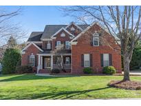 Brick home with a large front porch and landscaping at 7005 Shadow Rock Ct, Matthews, NC 28104