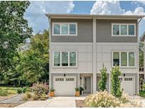 Modern two-story home with gray siding, attached garage, and landscaped front yard at 7324 Swans Run Rd, Charlotte, NC 28226