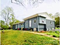 Updated exterior boasts a modern gray color scheme and spacious lawn at 1016 Patricia Ave, Harrisburg, NC 28075