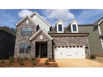 Beautiful stone and siding exterior featuring a two-car garage and manicured front yard at 1136 Yellow Springs Dr, Huntersville, NC 28078