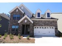 Charming two-story home with a beautiful stone facade and a white garage door, offering a blend of modern and traditional design at 1136 Yellow Springs Dr, Huntersville, NC 28078