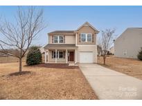 Two-story house with beige vinyl siding, brown door, and attached garage at 1178 Valley St, Statesville, NC 28677