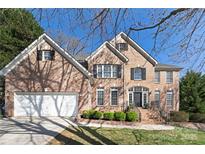 Beautiful two-story brick home with a manicured lawn and attached two-car garage at 11805 Farnborough Rd, Huntersville, NC 28078