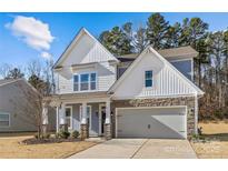 Two-story home with gray siding, stone accents, and a two-car garage at 2151 Black Forest Cv, Concord, NC 28027