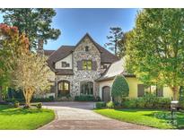 Exterior of a stunning stone house with a large driveway and lush landscaping at 1105 Hadley Park Ln, Weddington, NC 28104
