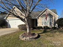 Beige house with two-car garage and American flag at 2215 Ballingarry Dr, Statesville, NC 28625