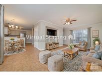 Inviting living room with tile floors, ceiling fan, large windows, and comfortable seating at 5110 Osage Cir, Charlotte, NC 28269