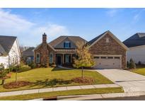 Inviting two-story home with stone accents and landscaped lawn at 82112 Standing Oak Dr, Charlotte, NC 28278