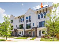 Newly constructed townhomes feature brick accents, white siding, black balconies, and beautifully landscaped grounds at 1229 E 34Th St # Csw0421, Charlotte, NC 28205