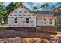 New construction home featuring brick foundation, steps to front door, and prepared yard for final grading at 1235 Ebinport Rd, Rock Hill, SC 29732