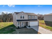 Two-story house with gray siding, a two-car garage, and rocking chairs on the porch at 40 Harvest Ridge Dr, Hickory, NC 28601