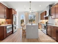 Bright, modern kitchen with stainless steel appliances, pendant lighting, and a large island with seating at 5620 Kingspan Dr, Charlotte, NC 28217