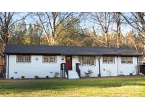 White ranch house with black roof, red door, and landscaped yard at 6726 Lockhart Rd, Sharon, SC 29742