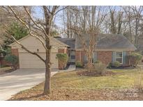 Brick ranch house with attached garage and landscaped yard at 9232 Sardis Forest Dr, Charlotte, NC 28270