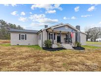 Gray brick ranch house with a front porch, rocking chairs, and landscaping at 1278 Burrell Rd, Clover, SC 29710