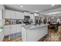 Modern kitchen with white cabinets, granite island, and stainless steel appliances at 1278 Burrell Rd, Clover, SC 29710