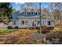 Gray house with gray roof, red door, and landscaping at 161 Picwyck Dr, Mooresville, NC 28115