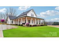 White farmhouse exterior with a large front porch and landscaped lawn at 243 Reese Wilson Rd, Belmont, NC 28012