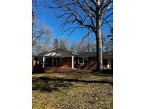Brick ranch house with covered porch, situated on a landscaped lot with mature trees at 315 S Morrow Ave, Albemarle, NC 28001