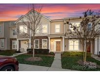 Tan two-story townhome with a gray door and landscaping at 408 Spring Gardens Dr, Belmont, NC 28012