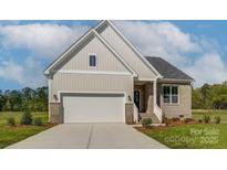 Beige house with white garage door and landscaping at 804 Pierce Ave, Mount Holly, NC 28120