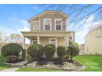 Two-story house with beige siding, front porch, and landscaping at 19054 Long Pond Ln, Cornelius, NC 28031