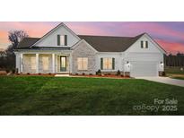 Charming one-story home features a combination of stone and vinyl siding, green shutters, and a well-manicured lawn at 3432 Greene Rd, Monroe, NC 28110