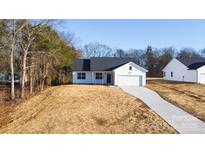 White house with gray roof, two-car garage, and driveway at 4109 Pebblebrook Sw Cir, Concord, NC 28027