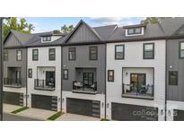 Modern townhouses with gray and white exterior, balconies, and attached garages at 8723 Nolley Ct, Charlotte, NC 28270