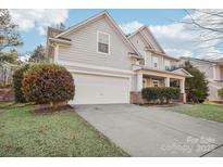 Gray sided two story house with a white garage door and landscaping at 8814 Beaver Creek Dr, Charlotte, NC 28269