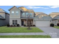 Two-story house with stone and shingle accents, a two-car garage, and a landscaped lawn at 13206 Carolina Wren Ct, Charlotte, NC 28278