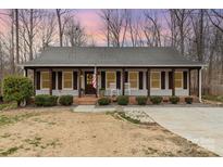 Charming single-story home featuring a welcoming front porch, rocking chairs, and well-manicured landscaping at 348 Sugar Creek Xing, Fort Mill, SC 29715