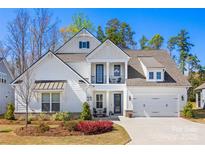 Beautiful two-story home featuring a two car garage, manicured lawn, and second-story balcony at 7150 Irongate Dr, Indian Land, SC 29707
