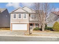 Two-story house with beige siding, a white garage door, and landscaping at 3103 Less Traveled Trl, Indian Trail, NC 28079