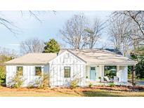Charming single-story home with light blue door, covered porch, and beautiful landscaping at 711 Concord Rd, Davidson, NC 28036