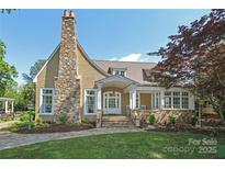 Charming two-story home with stone chimney, landscaped front yard, and inviting front porch at 1333 Carlton Ave, Charlotte, NC 28203