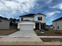 Two-story home featuring white siding, a two-car garage, and a well-manicured front yard with 'for sale' signage at 1515 Harper Landing Blvd, Stanley, NC 28164