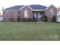 Brick ranch home with landscaped lawn and attached garage at 1601 Eden Glen Dr, Dallas, NC 28034