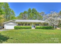 Charming ranch-style home featuring a welcoming front porch and lush green lawn at 16415 Capps Rd, Charlotte, NC 28278