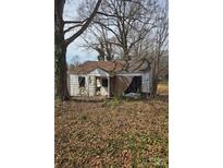 Weathered one-story home featuring peeling paint and a yard covered in fallen leaves at 1902 5Th St, Statesville, NC 28677