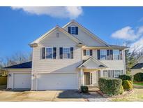 Two-story house with beige siding, dark shutters, and a two-car garage at 3043 Streamlet Way, Monroe, NC 28110