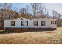 White single-wide mobile home with brick skirting and a covered porch at 461 Ret Stafford Ln, Taylorsville, NC 28681