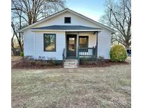 Charming white house with gray accents, a covered porch, and well-maintained landscaping at 563 Sparta Nw St, Concord, NC 28025