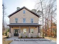Two-story brick home with a front porch and landscaping at 604 Impala Dr, Albemarle, NC 28001