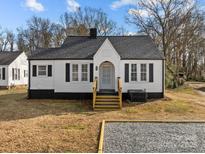 Charming white house with black accents, a gravel driveway and small front yard at 1004 N Salisbury Ave, Spencer, NC 28159