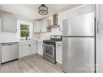 Updated kitchen with stainless steel appliances and gray cabinets at 123 Lincoln St, Statesville, NC 28677