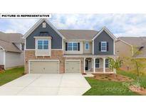 Two-story home with gray siding, stone accents, and a two-car garage at 193 Asmodean Ln, Troutman, NC 28166